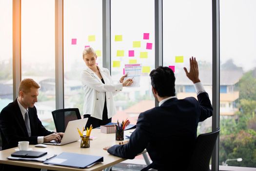 young business team working together at office. Manager pointing at a chart and explaining the analysis about business strategies. Top view shot of business hand shake