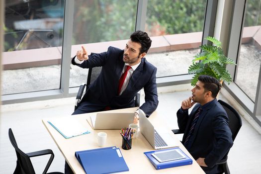 young business team working together at office. Manager pointing at a chart and explaining the analysis about business strategies. Top view shot of business hand shake