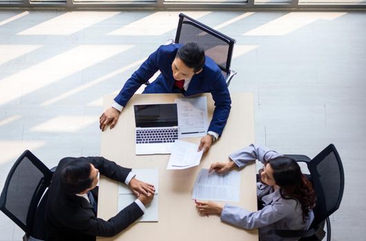 Top view on a group of businessman and businesswoman having a meeting and making a business commitment.