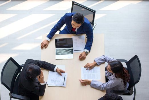 Top view on a group of businessman and businesswoman having a meeting and making a business commitment.