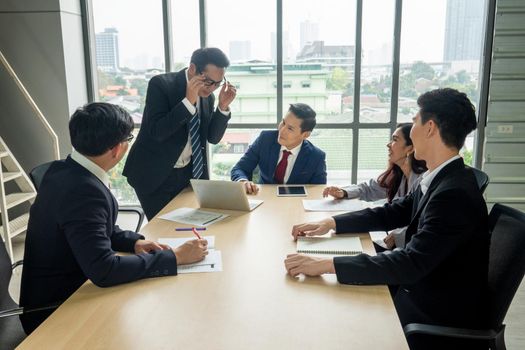 young business team working together at office. Manager pointing at a chart and explaining the analysis about business strategies. Top view shot of business hand shake