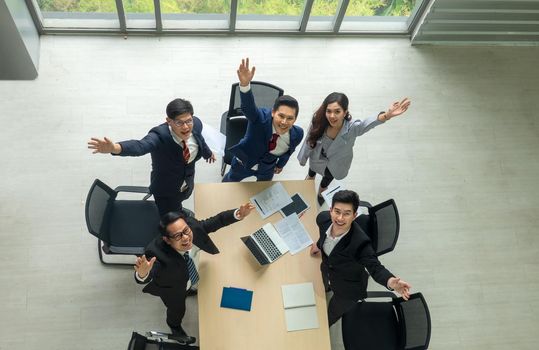 Top view on a group of businessman and businesswoman having a meeting and making a business commitment.