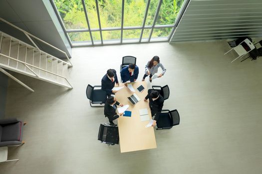 Top view on a group of businessman and businesswoman having a meeting and making a business commitment.