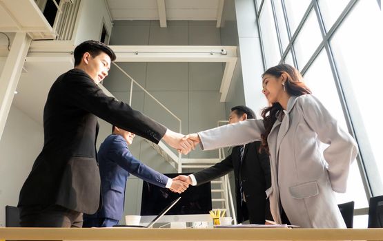 Business people shaking hands in the modern office finishing successful meeting