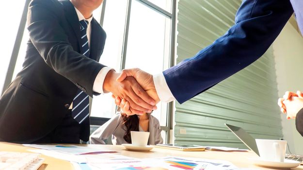 Business people shaking hands in the modern office finishing successful meeting