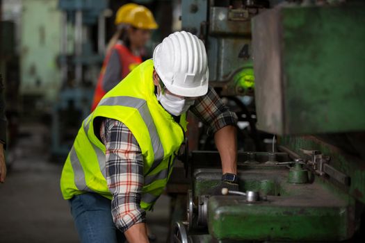 Engineers operating a cnc machine in factory