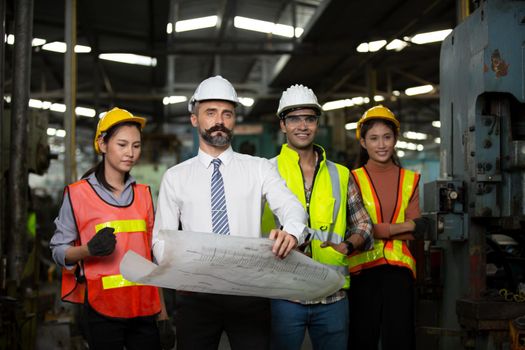 Male Industrial Engineers Talk with Factory Worker . They Work at the Heavy Industry Manufacturing Facility.