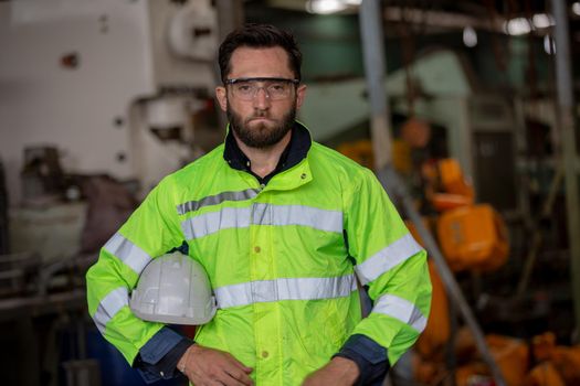 Portrait of female Engineer standing with confident against machine environment in factory, Engineers operating a machine in factory