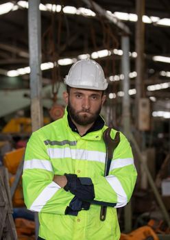 Engineer standing with confident against machine environment in factory