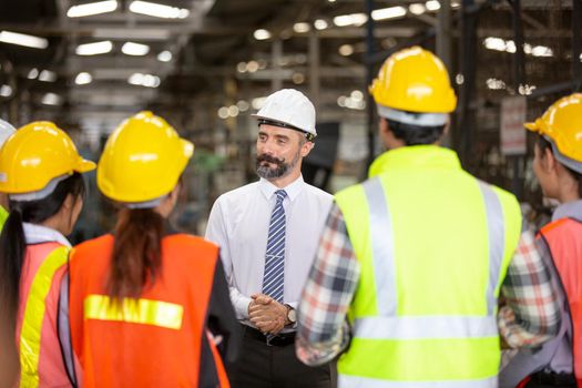 Male Industrial Engineers Talk with Factory Worker . They Work at the Heavy Industry Manufacturing Facility.