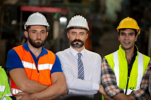 Male Industrial Engineers Talk with Factory Worker . They Work at the Heavy Industry Manufacturing Facility.