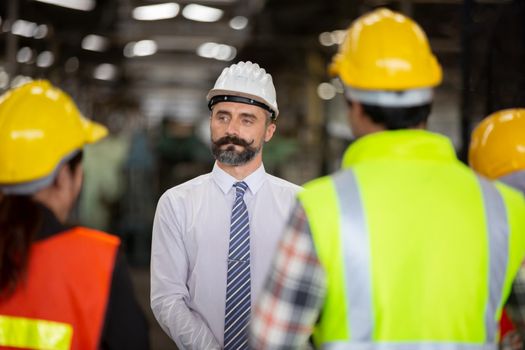 Male Industrial Engineers Talk with Factory Worker . They Work at the Heavy Industry Manufacturing Facility.