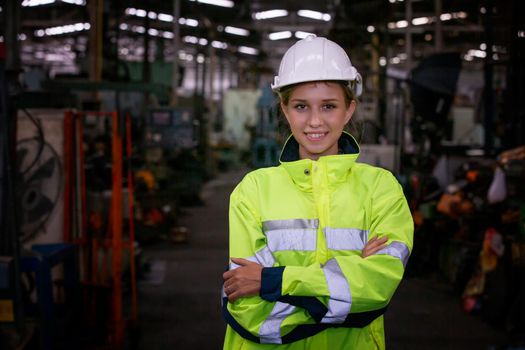 Portrait of female Engineer standing with confident against machine environment in factory