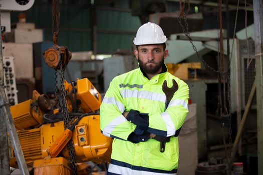 Engineer standing with confident against machine environment in factory