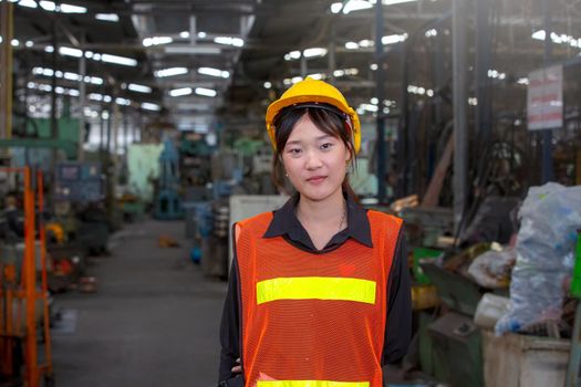 Portrait of female Engineer standing with confident against machine environment in factory