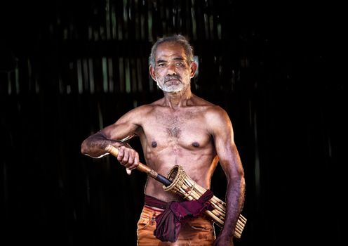 dark and sullen shot of a old man smoking over a black background