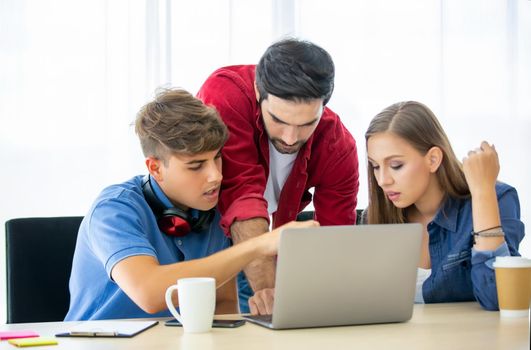 Business people working in office on desktop computer, Group of happy business people in smart casual wear looking at the laptop and gesturing. Achieving success.