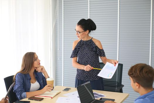 Business people working in office on desktop computer, Group of happy business people in smart casual wear looking at the laptop and gesturing. Achieving success.