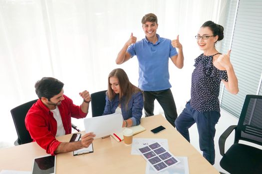 Business people working in office on desktop computer, Group of happy business people in smart casual wear looking at the laptop and gesturing. Achieving success.