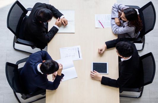 Top view on a group of businessman and businesswoman having a meeting and making a business commitment.