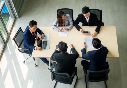 Top view on a group of businessman and businesswoman having a meeting and making a business commitment.