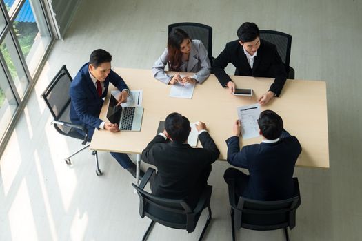 Top view on a group of businessman and businesswoman having a meeting and making a business commitment.