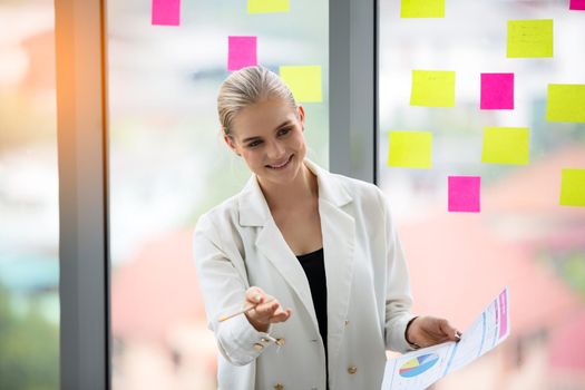 young business team working together at office. Manager pointing at a chart and explaining the analysis about business strategies. Top view shot of business hand shake