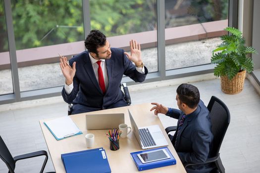 young business team working together at office. Manager pointing at a chart and explaining the analysis about business strategies. Top view shot of business hand shake