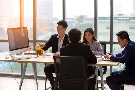 young business team working together at office. Manager pointing at a chart and explaining the analysis about business strategies. Top view shot of business hand shake