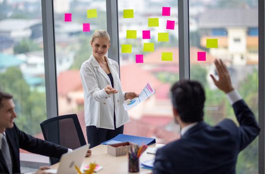 young business team working together at office. Manager pointing at a chart and explaining the analysis about business strategies. Top view shot of business hand shake