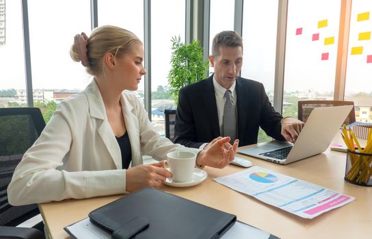 young business team working together at office. Manager pointing at a chart and explaining the analysis about business strategies. Top view shot of business hand shake