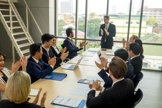 young business team working together at office. Manager pointing at a chart and explaining the analysis about business strategies. Top view shot of business hand shake