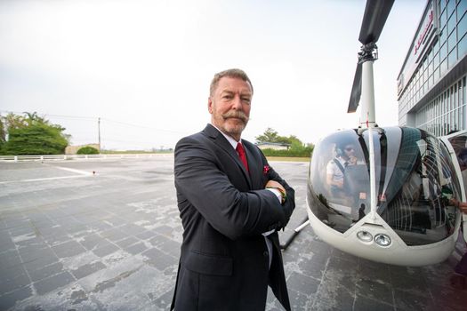 Business people traveling by helicopter , Shot of a mature businessman using a headset while traveling in a helicopter