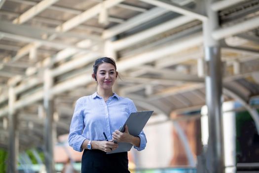 Businessman and women sitting on step outdoor looking on laptop against building