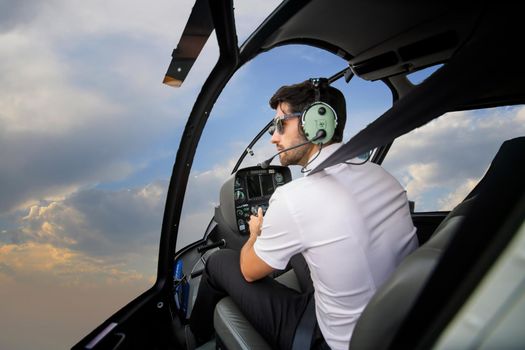 Shot of a mature Helicopter pilot using a headset while traveling in a helicopter, Business people traveling by helicopter