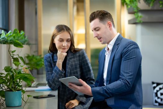 Two Cheerful Young Businessmen Using Laptop On Business Meeting Together