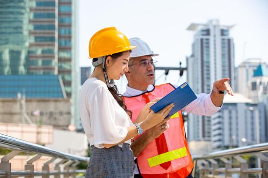 The engineer and business people hand high five against building. The concept of engineering, construction, city life and future.