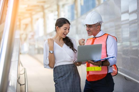 The engineer and business people hand high five against building. The concept of engineering, construction, city life and future.