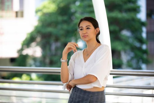 Portrait of young beautiful business woman at outside. Crossed arms