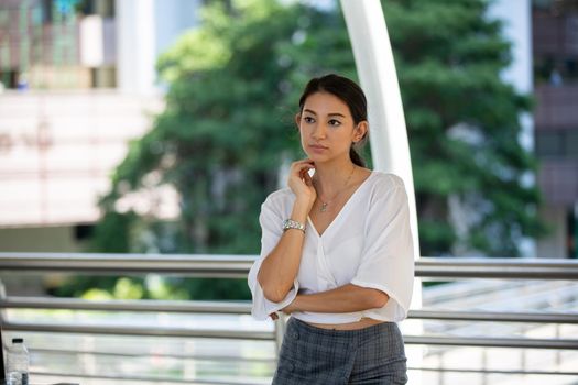 Portrait of young beautiful business woman at outside. Crossed arms