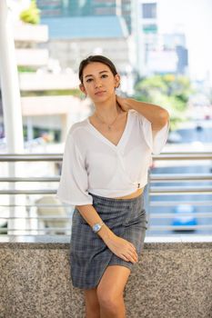 Portrait of young beautiful business woman at outside. Crossed arms