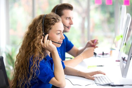 Call center team at the office. Call center operator in headset while consulting client. Telemarketing or phone sales. Customer service and business concept.
