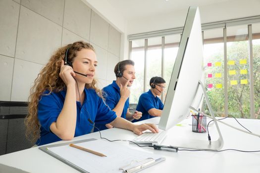 Call center team at the office. Call center operator in headset while consulting client. Telemarketing or phone sales. Customer service and business concept.