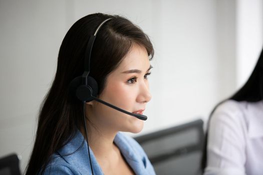 Call center operator in headset while consulting client. Telemarketing or phone sales. Customer service and business concept.