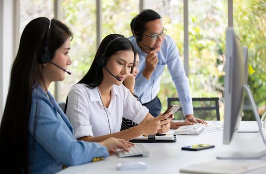 Call center operator in headset while consulting client. Telemarketing or phone sales. Customer service and business concept.