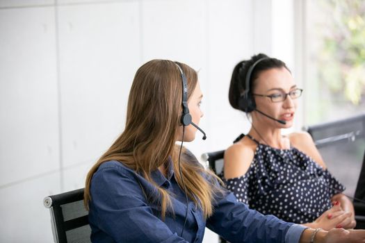 Call center operator in headset while consulting client. Telemarketing or phone sales. Customer service and business concept.