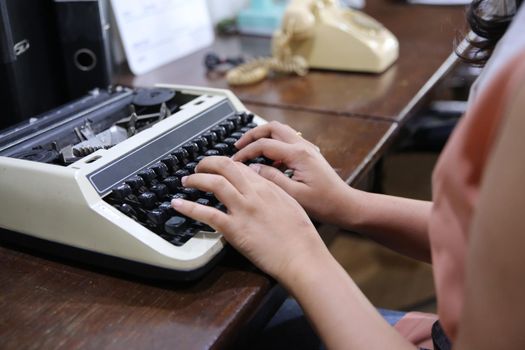 Close-up on women hand typing on type writer.