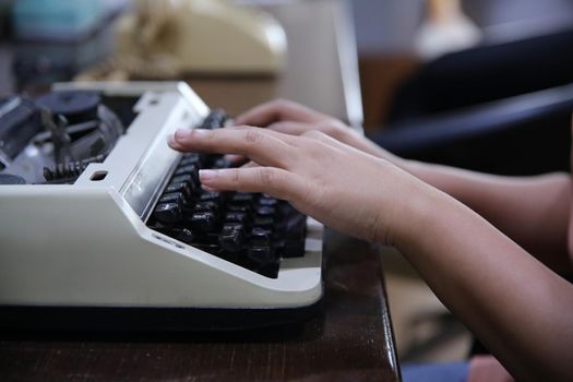 Close-up on women hand typing on type writer.