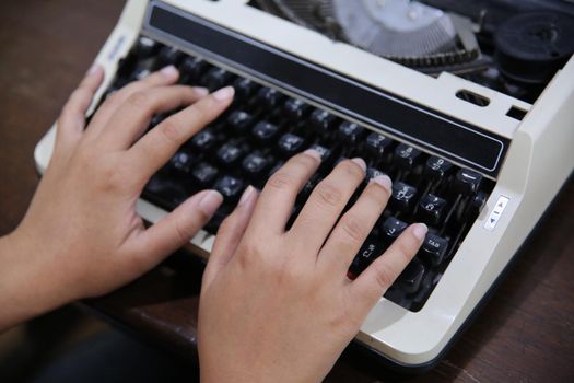 Close-up on women hand typing on type writer.