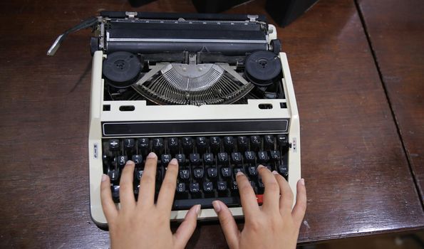 Close-up on women hand typing on type writer.